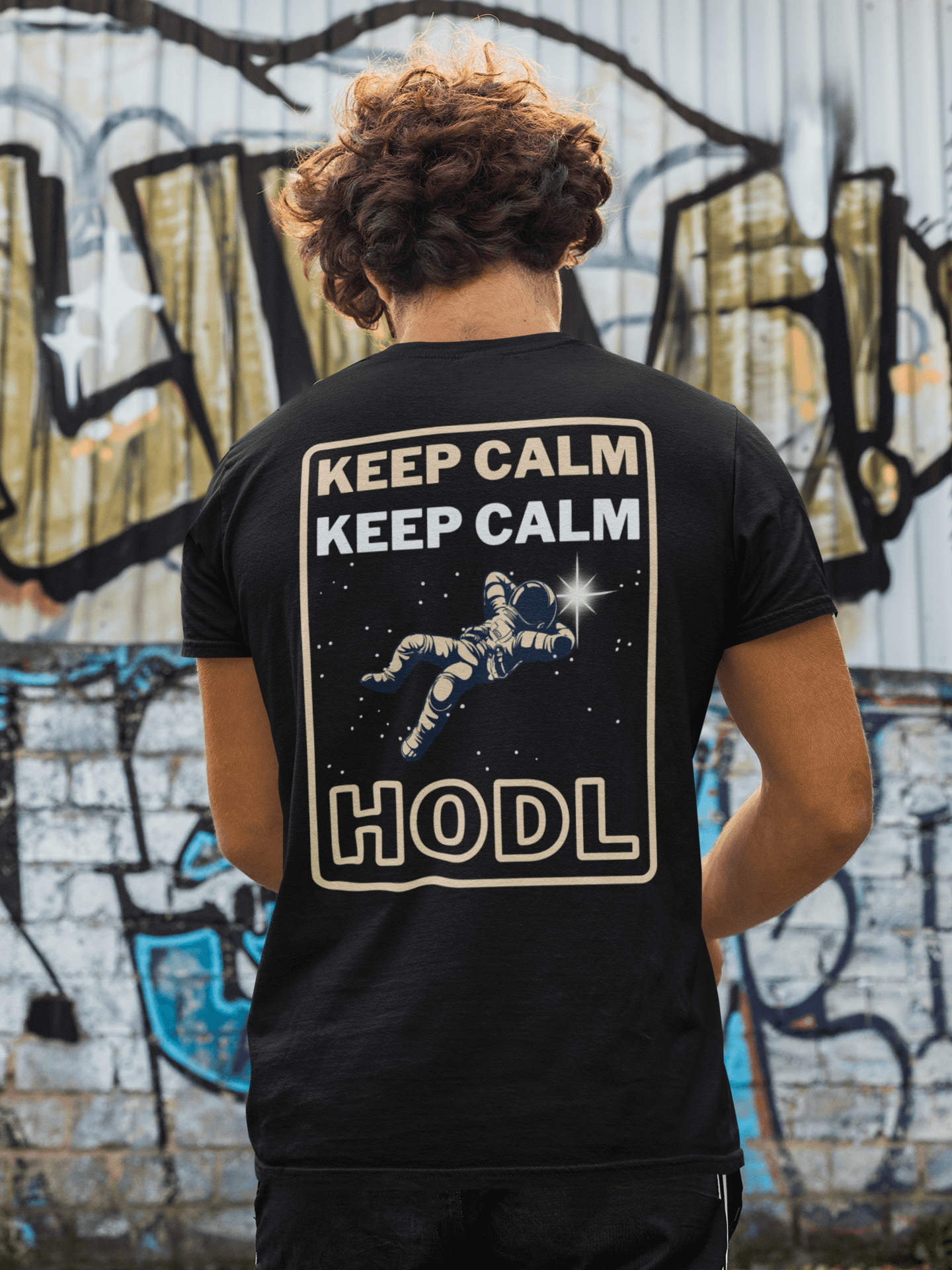 Man facing graffiti wearing "Keep calm and HODL" NFT T-shirt